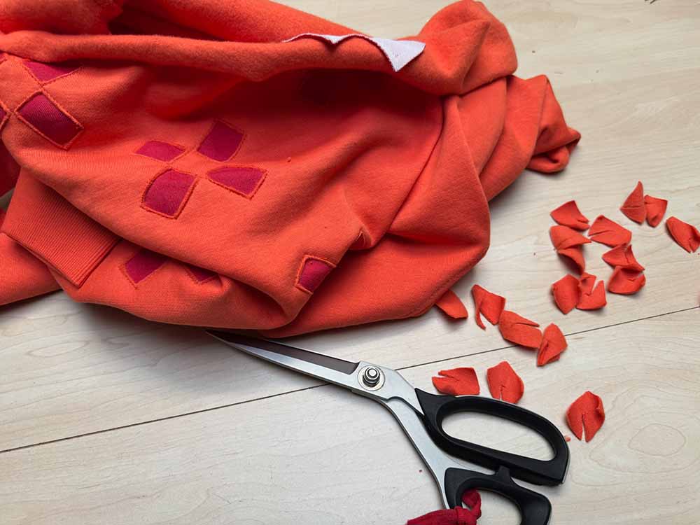Het handmatig knippen van hoogwaardig katoen voor de design sweatersvan Clau-d, sweaters in eigen beheer.