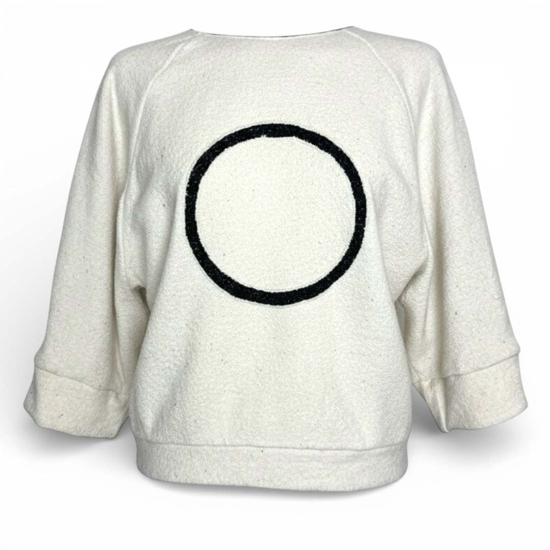 De Grey/ecru Circle Top is een statement piece waarin luxe materialen en grafisch minimalisme samenkomen. Deze oversized cropped top van CLAU-D combineert de verfijnde glans van zijde met de natuurlijke warmte van wol, wat resulteert in een kledingstuk dat zowel ademt als comfort biedt.