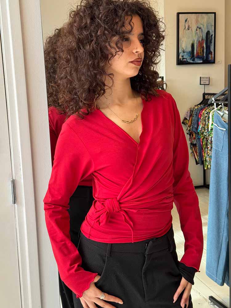 Klassieke look: rood handgemaakt wikkelvest van CLAU-D gestrikt aan de zijkant voor een slanke taille.