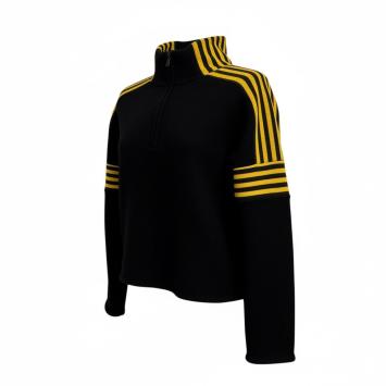 Schuin aanzicht van de zwarte merino trui met gele accenten bij de opgeknipte hals.