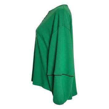 Zijaanzicht van de Green Block trui van CLAU-D, waarbij de relaxte fit, de prachtige ballonmouwen en het zwarte piping biesje